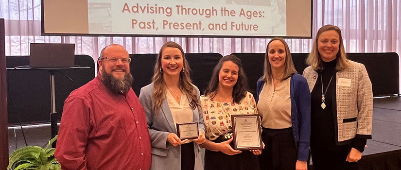 Five advisors are picture holding their award plaque. There are 4 white women and one african-american male. 