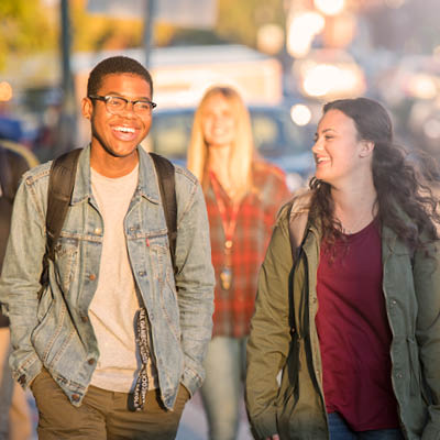 Two students walking and laughing together outside.