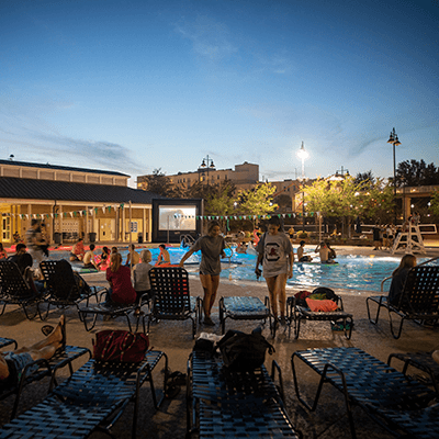 Students watching a movie on an outdoor screen at the Strom pool.