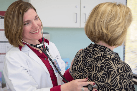 woman with stethascop examines patient