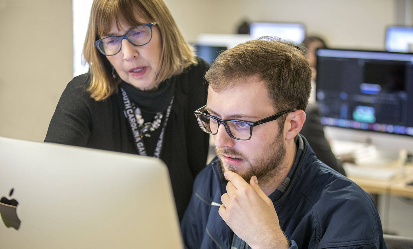 faculty member assisting student in class