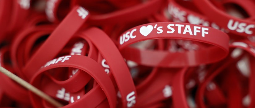 Bracelets that say "USC Loves Staff"