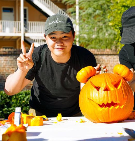 Student carving a pumpkin