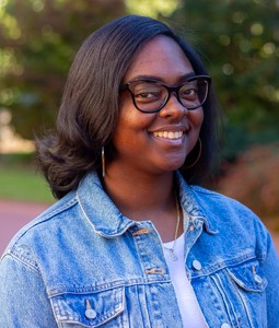 photo of a woman smiling with a jean jacket on outside