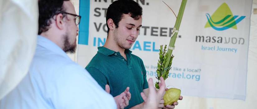 Young man standing holding a large fruit