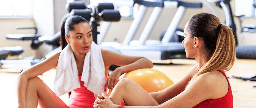 two women speaking in a gym