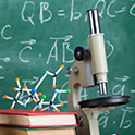 Microscope in front of a blackboard filled with math formulae