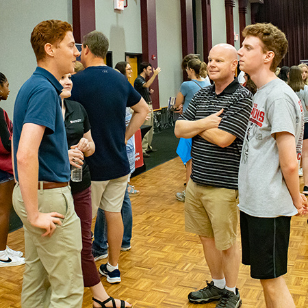 A member of the Leaders Program speaks with a prospective student at a UofSC Open House event.