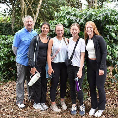 Students and an instructor pose for a photo outside a cafe in the Galapagos.