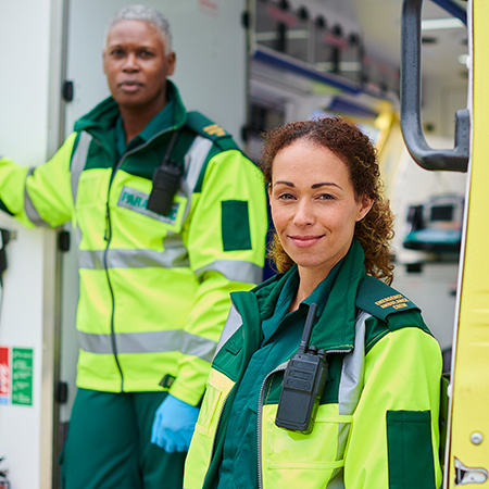 Two medics pose outside an ambulance