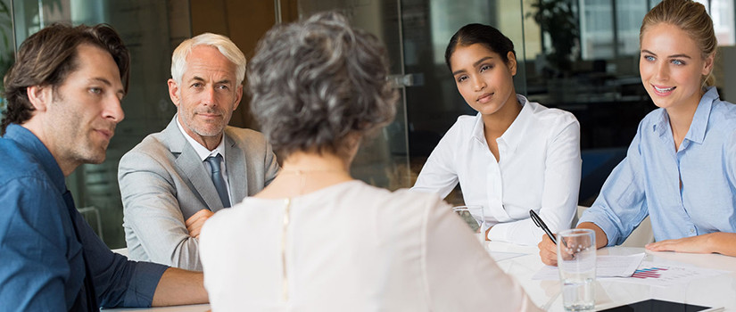 A small group of people in a conference room learn about supporting people with disabilities