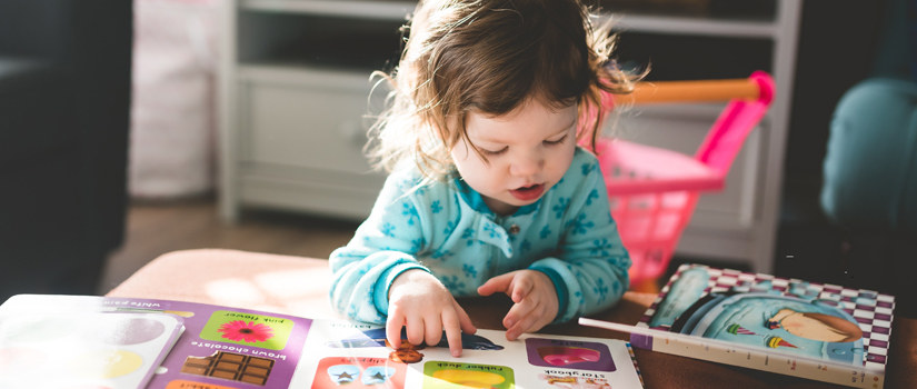 Young child explores adapted books.