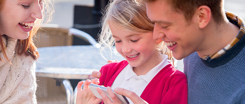 Parents with child looking at an i-phone