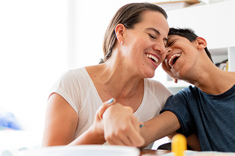 Mother and child with disability laughing together