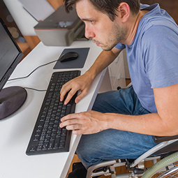 Man in wheelchair using computer