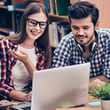 man and woman looking at laptop computer