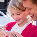 father and daughter looking at an iphone