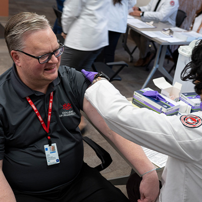 Godwin receiving flu shot from student