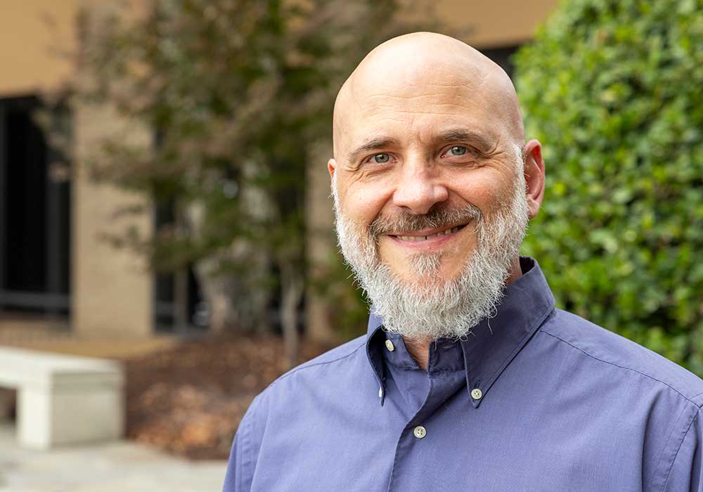 Kevin Bennett smiles outside the School of Medicine Columbia