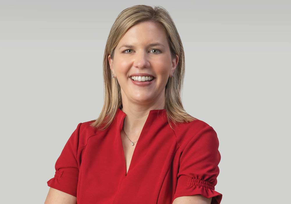 A portrait of Elizabeth Crouch with the Arnold School of Public Health in the background.