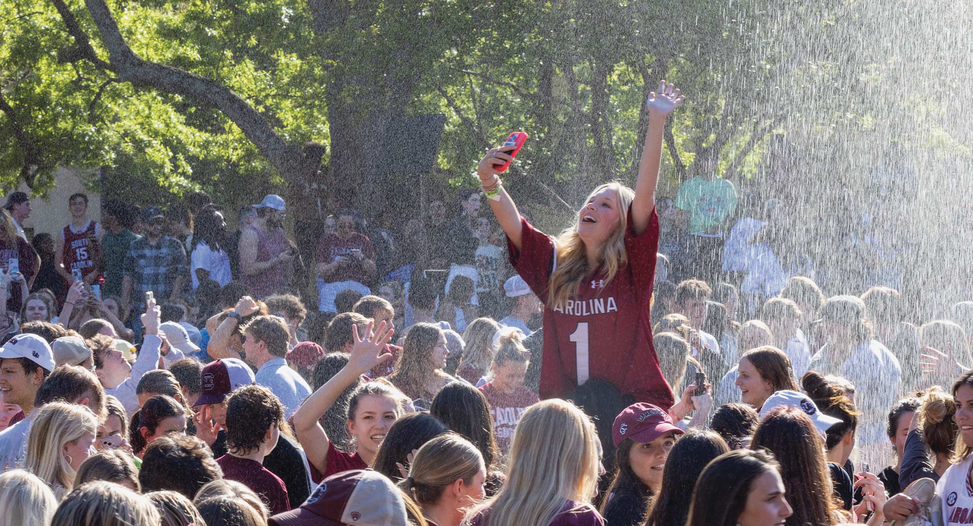 Students celebrate the womens basketball championship win at the Thomas-Cooper reflecting pool.