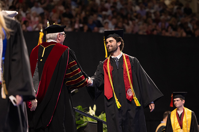 graduating student shaking hands on stage