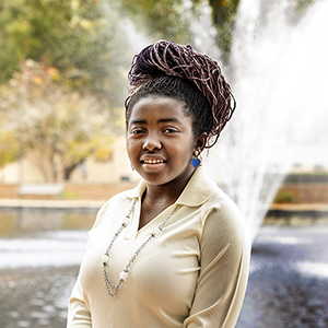 Korebami Adebajo stands in front of the fountain at USC's Thomas Cooper Library.