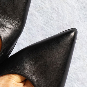 A woman's toes stuffed into a pointy black pump