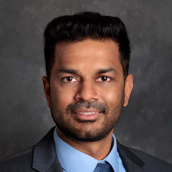 A studio portrait of assistant professor of medicine Deepak Bhere.